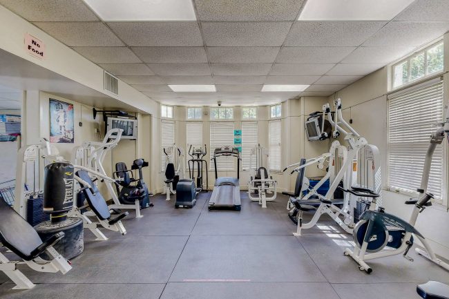 Indoor gym room full of different types of workout equipment